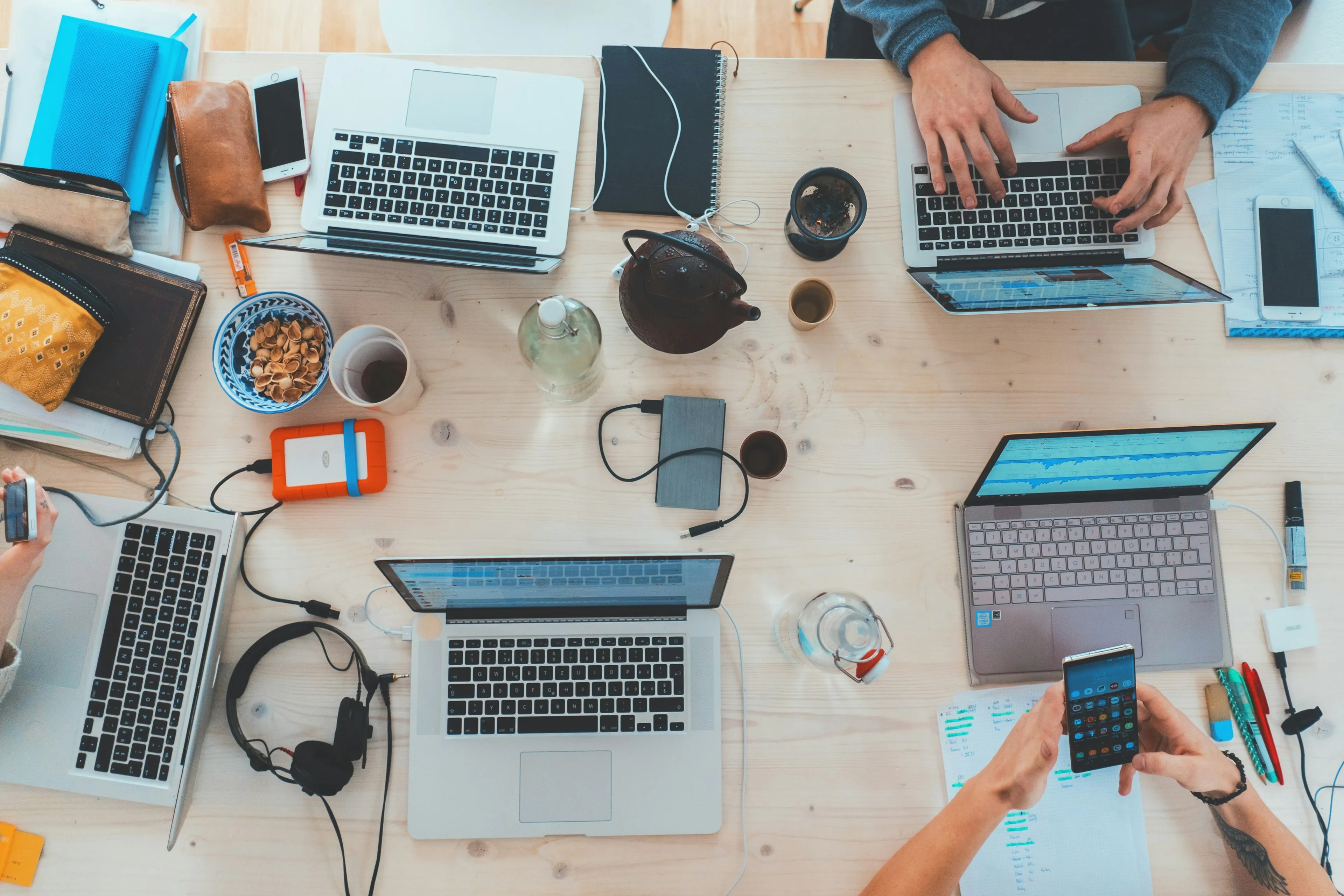 Une table de travail vue de dessus, chacun devant son écran